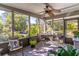 Relaxing screened porch with ceiling fan and comfortable seating overlooking lush landscaping at 410 N Niblick Ln, Lake Mary, FL 32746