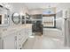 Bright bathroom with double sinks, shower, and soaking tub beneath an arched window at 419 Coventry Rd, Davenport, FL 33897