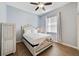 Cozy bedroom featuring wood floors, ceiling fan, and a queen bed, alongside natural light at 419 Coventry Rd, Davenport, FL 33897