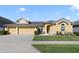Charming yellow home with a well-manicured lawn and a three-car garage at 419 Coventry Rd, Davenport, FL 33897