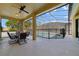 Covered patio overlooking a screened-in pool with a safety fence and outdoor seating area at 419 Coventry Rd, Davenport, FL 33897