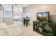 Inviting living room featuring tile flooring, entertainment center, and a view into the dining area at 4314 Pershing Pointe Pl # 4, Orlando, FL 32822