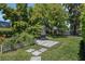 Lush backyard with mature trees, a patio with a grill, and a vegetable garden, creating a tranquil outdoor space at 504 Sonata Ct, Winter Springs, FL 32708