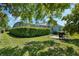 Private backyard with lush landscaping, mature trees, screened pool enclosure, and barbecue grill at 504 Sonata Ct, Winter Springs, FL 32708