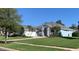 Inviting one-story home with a lush green lawn, mature landscaping, and stylish architectural details at 504 Sonata Ct, Winter Springs, FL 32708