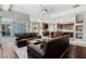 Open-concept living room with dark wood floors, leather furniture, and a seamless flow into the kitchen at 504 Sonata Ct, Winter Springs, FL 32708