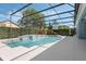 Sparkling in-ground pool with spa, lush greenery, and privacy screening within a screened enclosure at 504 Sonata Ct, Winter Springs, FL 32708