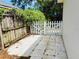 Small backyard patio with weathered white picket gate and fence with lush greenery beyond at 511 Terrier Way, New Smyrna Beach, FL 32168