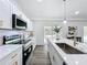 Modern kitchen with white cabinetry, stainless steel appliances, and quartz countertops at 533 Baxter St, Orlando, FL 32806