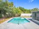 Inviting swimming pool surrounded by concrete and lush landscaping in a private backyard at 533 Baxter St, Orlando, FL 32806