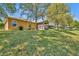 Large backyard with green grass, shade trees, and a view of neighboring properties at 5910 Windsong Oak Dr, Leesburg, FL 34748