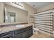 Neutral bathroom featuring tile flooring, a dark vanity, and a shower-tub combo at 5910 Windsong Oak Dr, Leesburg, FL 34748