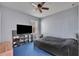 Neutral bedroom with carpet, a ceiling fan, TV on a shelving unit, and a large bed at 5910 Windsong Oak Dr, Leesburg, FL 34748