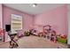 Playful pink bedroom with a collection of toys and plenty of natural light at 5910 Windsong Oak Dr, Leesburg, FL 34748