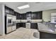 Well-lit kitchen featuring dark cabinets and stainless steel appliances at 5910 Windsong Oak Dr, Leesburg, FL 34748