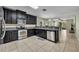Modern kitchen featuring stainless steel appliances, ample counter space, and sleek black cabinets at 5910 Windsong Oak Dr, Leesburg, FL 34748