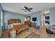 Stylish primary bedroom featuring a ceiling fan and wood flooring at 5910 Windsong Oak Dr, Leesburg, FL 34748