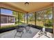Enclosed patio with outdoor seating, offering a serene view of the surrounding greenery at 5910 Windsong Oak Dr, Leesburg, FL 34748