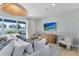 Modern living room features a white sofa, large TV, and seamless transition to an outdoor patio space at 6021 Tree Crossing Ln, St Cloud, FL 34771