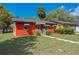 Front exterior view of a colorful single-story home with a well-maintained lawn at 612 Kensington St, Eustis, FL 32726