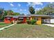 Brightly painted single-story home with carport and front lawn at 612 Kensington St, Eustis, FL 32726