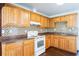 Functional kitchen with wooden cabinets, white appliances, and mosaic backsplash at 612 Kensington St, Eustis, FL 32726