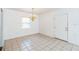 Bright living room featuring tile flooring, a chandelier, and a white front door at 612 Kensington St, Eustis, FL 32726