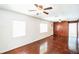 Spacious living room featuring hardwood floors, wood paneling, and ceiling fans at 612 Kensington St, Eustis, FL 32726