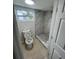 Modern bathroom features a toilet, window, and shower with elegant marble-look tiling at 6130 Gamble Dr, Orlando, FL 32808