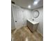 Bathroom includes a sink with gray cabinets, white countertop, round mirror, and door at 6130 Gamble Dr, Orlando, FL 32808