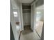 Hallway view with closet and doorway leading into a sunlit bedroom, featuring neutral tile flooring at 6130 Gamble Dr, Orlando, FL 32808