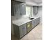 Updated kitchen features gray cabinets, stainless steel dishwasher and stone countertops at 6130 Gamble Dr, Orlando, FL 32808