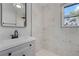 Modern bathroom with a vanity, sink, faucet, tiled shower and window with natural light at 819 State Ave, Daytona Beach, FL 32117