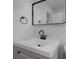 Close-up of a bathroom vanity with a rectangular framed mirror and modern black fixtures at 819 State Ave, Daytona Beach, FL 32117