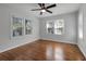 Bright bedroom featuring hardwood floors, a ceiling fan, and two windows providing natural light at 819 State Ave, Daytona Beach, FL 32117