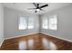 Bedroom with hardwood flooring, light walls, ceiling fan, and good natural light from the windows at 819 State Ave, Daytona Beach, FL 32117