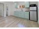 Kitchen with white appliances, light blue cabinets, and a light-wood floor at 831 Wolf Trl, Casselberry, FL 32707