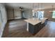 Open-concept kitchen with island, white cabinetry, stainless steel appliances, and wood-look floors at 947 Ferne Dr, Longwood, FL 32779