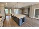 Open-concept kitchen with island, white cabinetry, stainless steel appliances, and wood-look floors at 947 Ferne Dr, Longwood, FL 32779