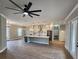 Open-concept living room with island kitchen, white cabinetry, stainless steel appliances, and wood-look floors at 947 Ferne Dr, Longwood, FL 32779