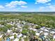 Expansive aerial view showcasing a mobile home community surrounded by lush greenery, and mature trees at 105 Canal Vw, Eustis, FL 32726