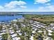 Scenic aerial view of community homes, lush greenery, and proximity to a stunning blue lake at 105 Canal Vw, Eustis, FL 32726