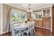 Bright dining room with a white table, wood floors, and scenic views through large windows at 105 Canal Vw, Eustis, FL 32726