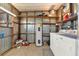 Functional laundry room with washer, dryer, water heater, and storage shelves at 105 Canal Vw, Eustis, FL 32726