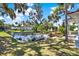 Scenic waterfront view with a boat docked, lush green lawn, and picturesque landscaping enhancing the property's appeal at 105 Canal Vw, Eustis, FL 32726