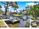 Beautiful waterfront view with a boat in the canal and houses in the background, surrounded by palm trees at 105 Canal Vw, Eustis, FL 32726