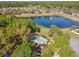 Aerial view featuring a community pool, nearby pond with fountain, landscaping, and trees at 1233 Bramley Ln, Deland, FL 32720