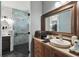Bathroom with vanity, sink, framed mirror, and a glass-enclosed walk-in shower with rain shower head at 1233 Bramley Ln, Deland, FL 32720