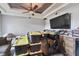 Cluttered living room features gray walls, a tray ceiling, a ceiling fan, and a large TV at 1233 Bramley Ln, Deland, FL 32720