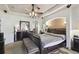 Spacious primary bedroom featuring a tray ceiling, ceiling fan, and dark wood furniture at 1233 Bramley Ln, Deland, FL 32720